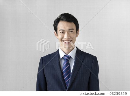 A smiling businessman in his thirties looking at the camera portrait 98239839