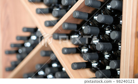 Various wine bottles are stacked on wooden racks Various wine bottles are stacked on wooden racks 98240121