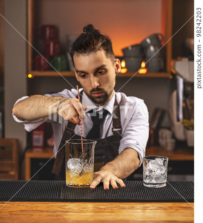 Barman stirring fresh alcoholic cocktail Barman stirring fresh alcoholic cocktail 98242203