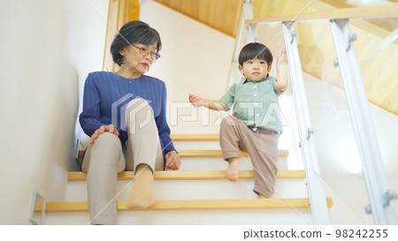 Grandmother watching over her two-year-old grandson 98242255