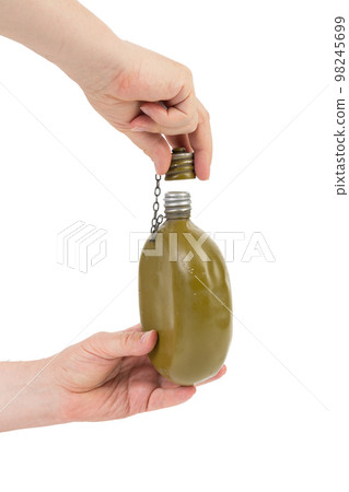 Military metal flask in a hand. Military metal flask in a hand. 98245699