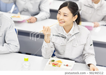 Men and women in work clothes eating lunch in the conference room 98246512