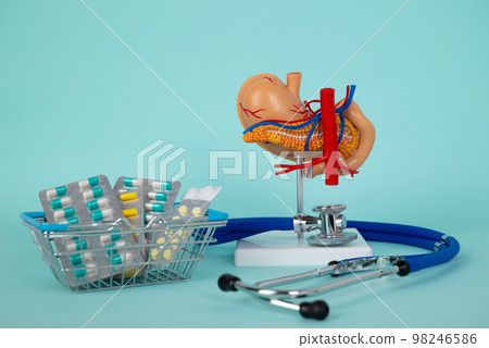 pancreas and stethoscope with a basket of pills lies on a blue background pancreas and stethoscope with a basket of pills lies on a blue background 98246586