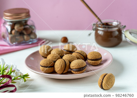 Hazelnut biscuits baci di dama or lady's kisses are traditional Italian dessert made as a sandwich with two cookies and chocolate cream.  98246760