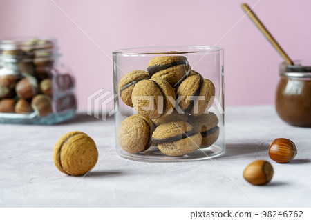 Hazelnut biscuits baci di dama or lady's kisses are traditional Italian dessert made as a sandwich with two cookies and chocolate cream. Hazelnut biscuits baci di dama or lady's kisses are traditional Italian dessert made as a sandwich with two cookies and chocolate cream. 98246762