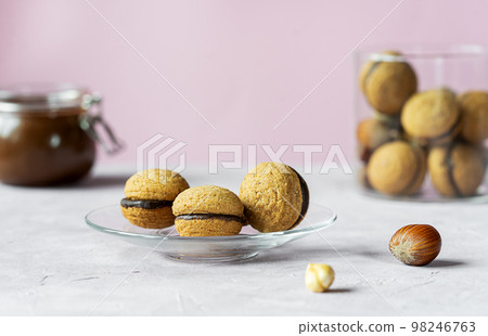 Hazelnut biscuits baci di dama or lady's kisses are traditional Italian dessert made as a sandwich with two cookies and chocolate cream.  98246763