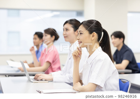 Healthcare workers undergoing training in a conference room 98246916