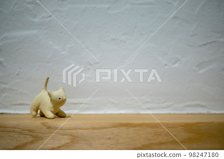 矽藻土牆前的無釉陶貓雕像 矽藻土牆前的無釉陶貓雕像 98247180