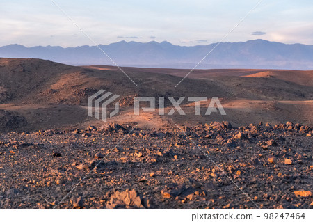 Stunning view of black and red rocky mountains with a river on the bottom Stunning view of black and red rocky mountains with a river on the bottom 98247464