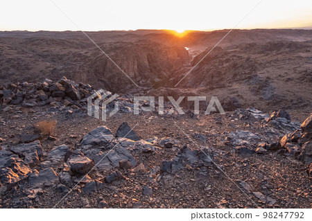 Stunning view of black and red rocky mountains with a river on the bottom 98247792