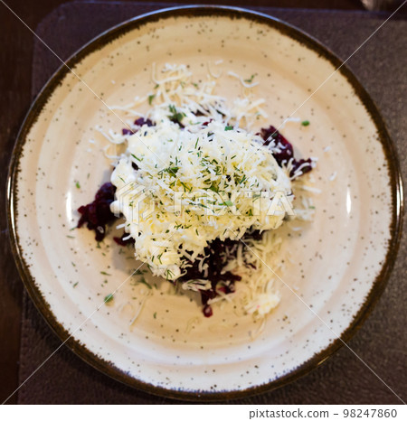 dish of beets, cheese, mayonnaise on a plate in restaurant. top view dish of beets, cheese, mayonnaise on a plate in restaurant. top view 98247860