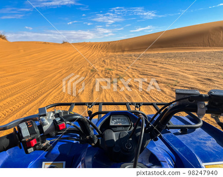 View of the dunes of the Sahara desert from a blue quad bike View of the dunes of the Sahara desert from a blue quad bike 98247940