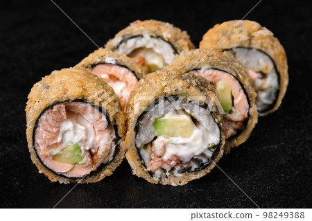 baked sushi rolls with salmon without rice on black baked sushi rolls with salmon without rice on black 98249388