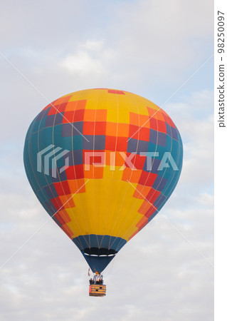 Colorful hot air balloon flying against grey sky at Winter aerostat festival Colorful hot air balloon flying against grey sky at Winter aerostat festival 98250097