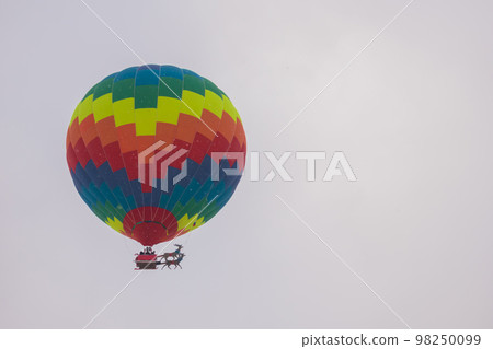 Colorful hot air balloon flying against grey sky at Winter aerostat festival 98250099