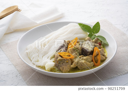Green Curry Chicken with Rice vermicelli in white plate on wooden table 98251709