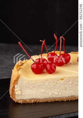 classic cheesecake decorated with cherries on a dark background classic cheesecake decorated with cherries on a dark background 98252246
