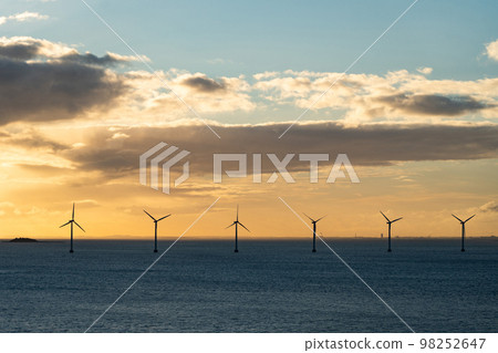 Wind farm generate electricity in the open sea during sunset. Environment and renewable technology Wind farm generate electricity in the open sea during sunset. Environment and renewable technology 98252647