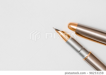 Close up of fountain pen lying on white blank paper background Close up of fountain pen lying on white blank paper background 98253159