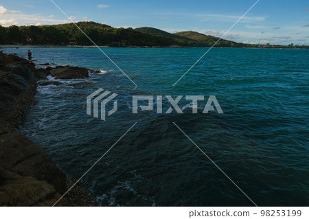 Rocky sea bach wave against blue sky Rocky sea bach wave against blue sky 98253199