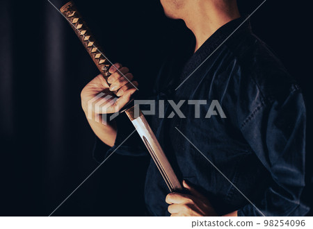 A person holding a Japanese sword A person holding a Japanese sword 98254096