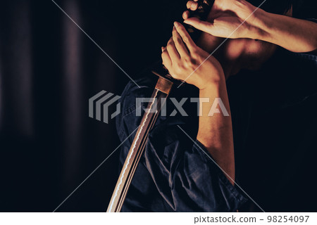 A person holding a Japanese sword A person holding a Japanese sword 98254097