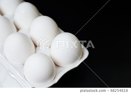 Tray with white chicken eggs on a dark background 98254818
