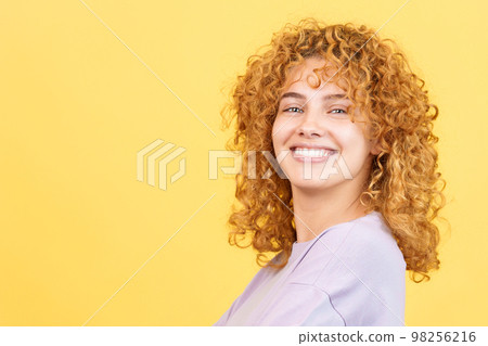 Happy woman turning to smile at the camera Happy woman turning to smile at the camera 98256216