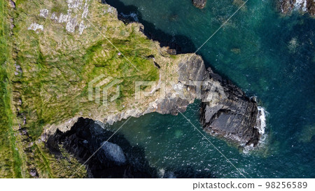 Grassy cliffs on the Atlantic Ocean coast. Landscape of Ireland from a height. Seaside rocks. Aerial photo. View from above. Grassy cliffs on the Atlantic Ocean coast. Landscape of Ireland from a height. Seaside rocks. Aerial photo. View from above. 98256589