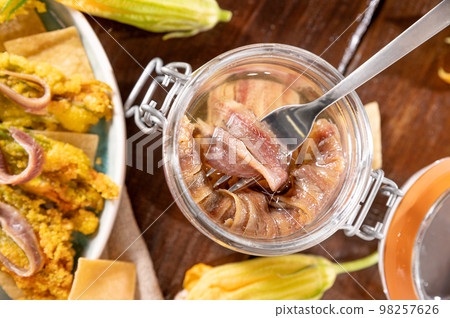 Anchovies in a jar, on a wooden rustic background. Traditional italian food of the south of italy 98257626