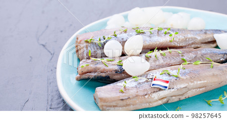 Freshly salted herring with salt, with copy space. Traditional Dutch delicacy. Freshly salted herring with salt, with copy space. Traditional Dutch delicacy. 98257645