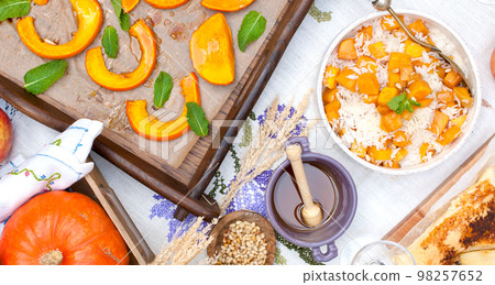 Pumpkin baked with honey and herbs. Autumn lunch, served table. View from above. Pumpkin baked with honey and herbs. Autumn lunch, served table. View from above. 98257652