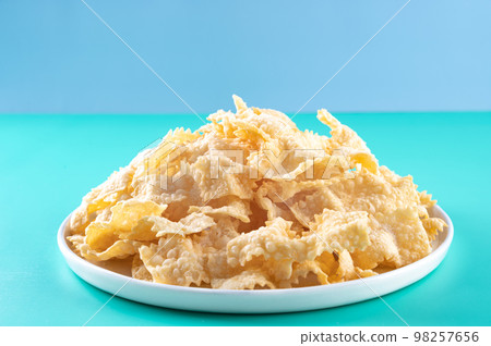Sfrappole or chiachiere or angel wings on a bright blue background. Italian Carnival and TYPICAL Sfrappole or chiachiere or angel wings on a bright blue background. Italian Carnival and TYPICAL 98257656