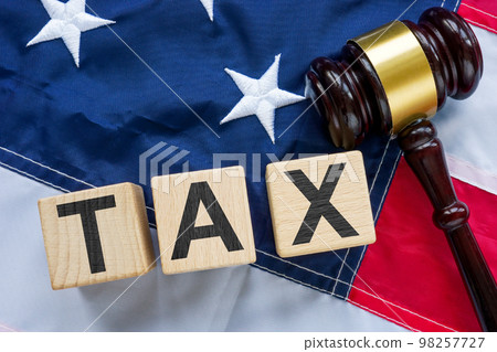 USA flag, gavel and cubes with word tax as a symbol of avoidance or fraud. USA flag, gavel and cubes with word tax as a symbol of avoidance or fraud. 98257727