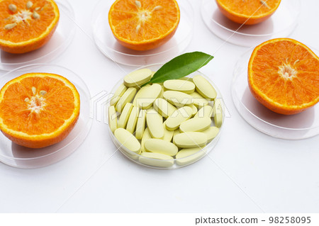 Vitamin C pills with fresh orange citrus fruit isolated on white background. Vitamin C pills with fresh orange citrus fruit isolated on white background. 98258095