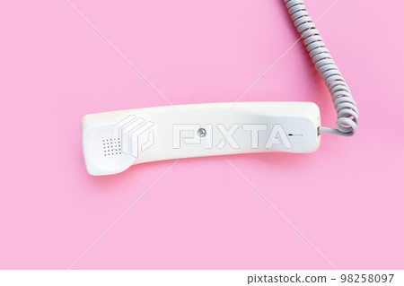 Handset of landline phone on pink background. Handset of landline phone on pink background. 98258097