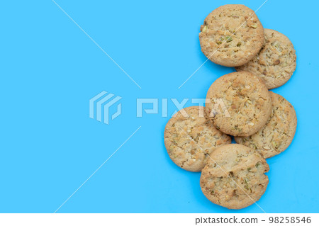 Pistachio and almond cookies on blue background. Pistachio and almond cookies on blue background. 98258546
