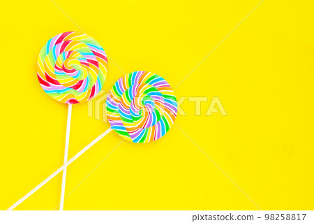 Rainbow lollipop on yellow background. Rainbow lollipop on yellow background. 98258817