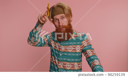 Magician wizard hippie man gesturing with magic wand making wish come true, casting magician spell 98259139