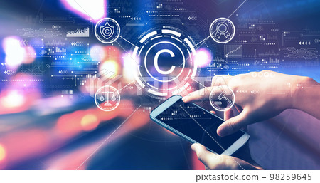 Copyright concept with person using a smartphone at night Copyright concept with person using a smartphone at night 98259645