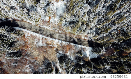 Aerial high angle view of narrow winding curvy mountain road. Aerial high angle view of narrow winding curvy mountain road. 98259681