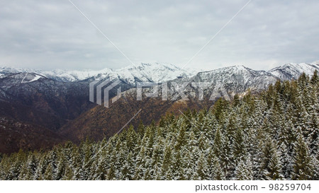 Winter landscape with snow covered mountain peaks. Winter landscape with snow covered mountain peaks. 98259704