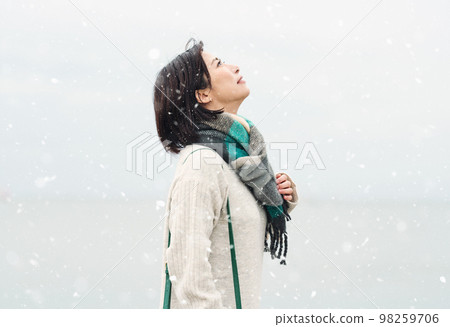 A woman going out to the sea in the snowy winter A woman going out to the sea in the snowy winter 98259706