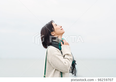 woman going out to the sea in winter 98259707