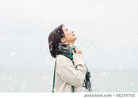 A woman going out to the sea in the snowy winter 98259708