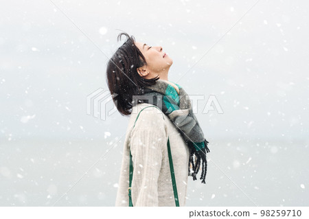 A woman going out to the sea in the snowy winter 98259710