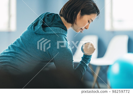 Woman training with iron array in gym 98259772