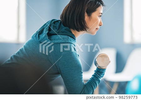 在健身房用鐵陣列訓練的女性 在健身房用鐵陣列訓練的女性 98259773