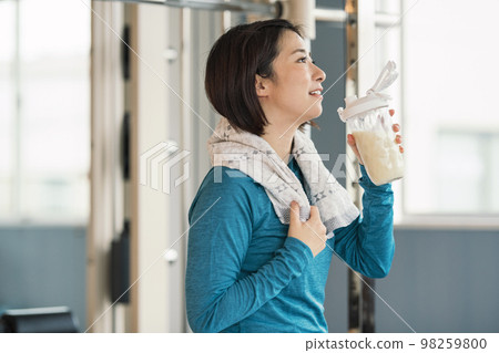 在健身房鍛煉肌肉後喝蛋白質的女人 98259800
