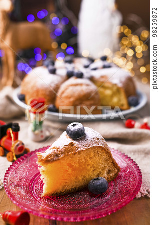 Christmas time in Italian tradition. Biscuit birthday cake with berries on the table 98259872